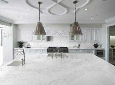 A renovated kitchen using white Mars Quartz on the countertop and backsplash. 