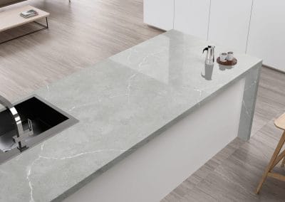 A quartz countertop in a light grey colour with a built in sink.